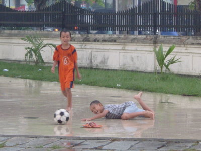 Kids playing soccer in front of a mosque in Medan