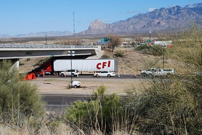 THE CARS AND TRUCKS WAIT IN LINE TO CLEAR THE CHECKPOINT