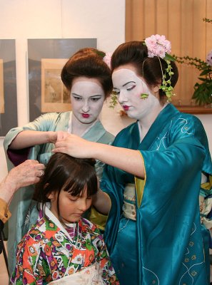 Maiko help to dress in kimono for young visitors