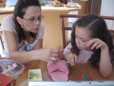 Aunt Melinda helping Leila sew her slipper