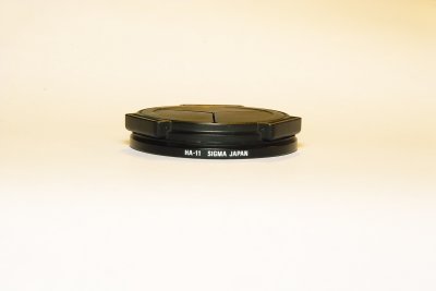 Ricoh LC-1 Auto Lens Cap attached to Sigma's HA-11 ring.