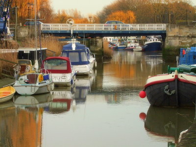 Boats clutter the River Stour by the bridge.