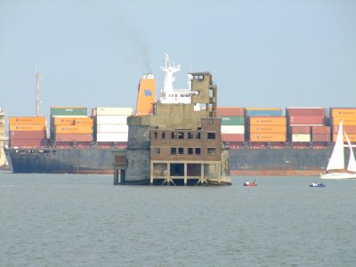 A container ship passing between the two forts.