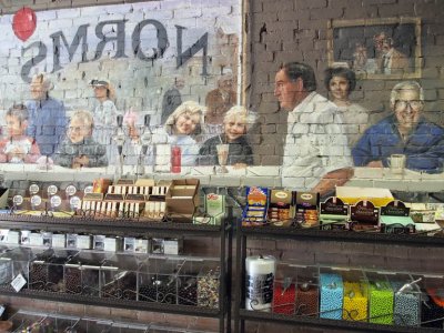 Small town life is on the wall behind the candy counter.