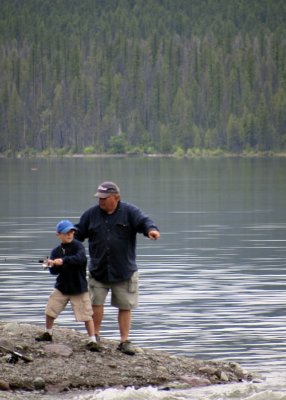 Dad teaches his son to fish.