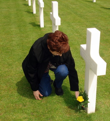 Carol placing a flower on a soldier's grave