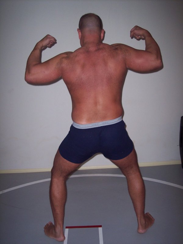 grapplers wrestling on mats flexing back muscles