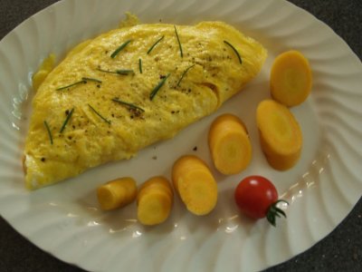 Cheese omlete with chives, carrot and tomato.