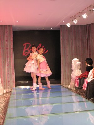 young customers of the Barbie flagship store in Shanghai walk the stores runway.