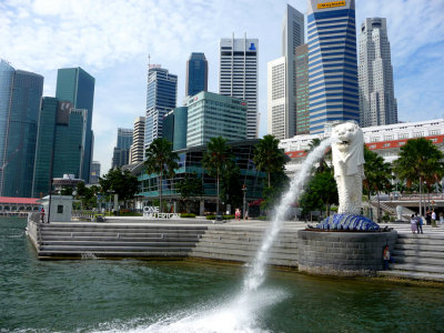 The Merlion stands on the Singapore River facing Singapore Harbor with water spouting out of its mouth.