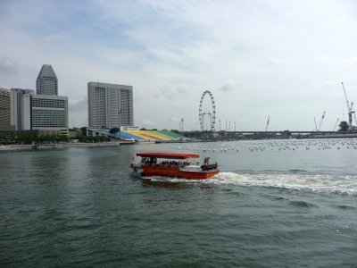 Boat on the Singapore River with the Singapore Flyer, the world's largest ferris wheel in the background. It is 165 m. high.