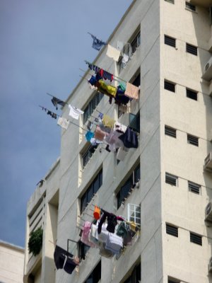 Colorful washing on the side of a building. This method of drying laundry to dry in Singapore is known as flagpole laundry.