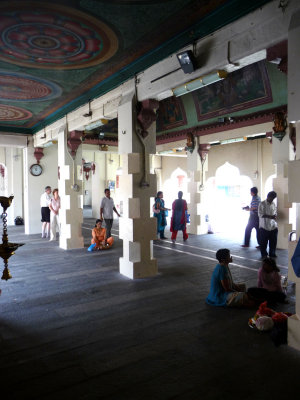 Interior of the temple with tourists and worshippers praying.
