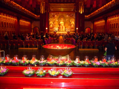 Interior of incredibly ornate Buddha Tooth Relic Temple with a golden Buddha in the background.