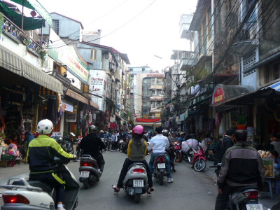 More motorbikes buzzing through Hanoi's crowded streets.