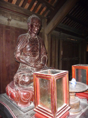 Wooden image of a man who is praying.