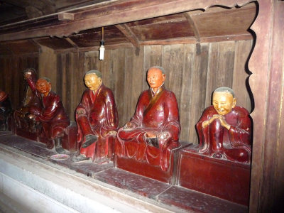 Wooden images of monks in different positions.