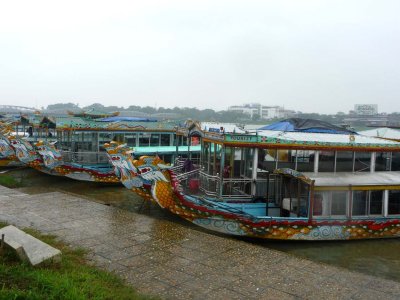 Tourist boats with dragon mastheads docked on the Perfume River in Hue.
