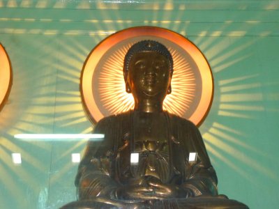 Close-up of the illuminated Buddhist image at the alter.