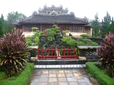 Landscaping in front of the pond with a Citadel building with a very elaborate roof in the background.