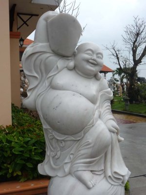 I was a good tourist and bought a miniature version of this happy Buddha sculpture there!