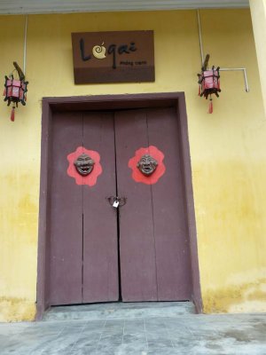 Hoi An doorway with interesting masks and lanterns.