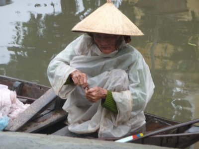 The old woman is doing something with her hands.