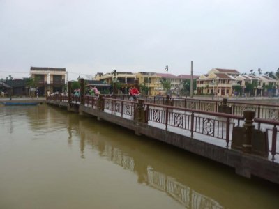 The Thu Bon River with pedestrians walking and biking across the bridge.
