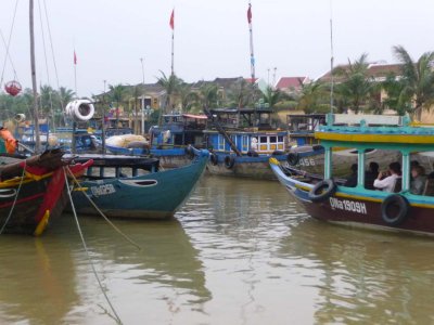 A mix of wooden tourist boats and fishing boats on the Thu Bon River.