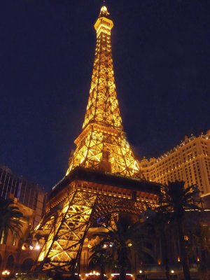 Close-up of the Eiffel Tower illuminated at night.