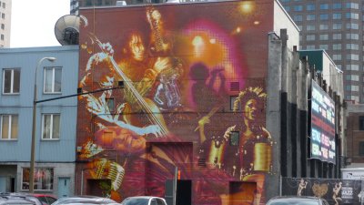 An iridescent orange and purple mural of a rock band.