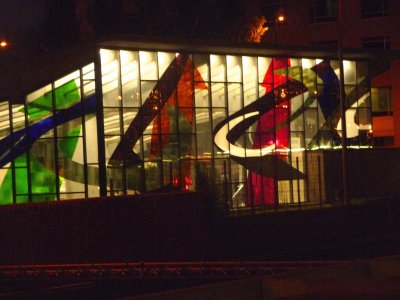 View of the colorful glass faade of the Champ-de-Mars Metro station at night.