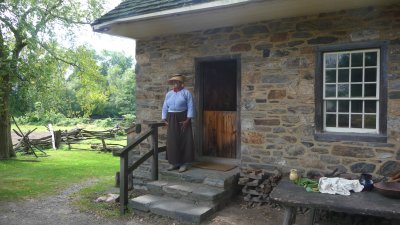 This costumed interpreter outside of the small stone house probably represents an enslaved African working at Philipsburg Manor.