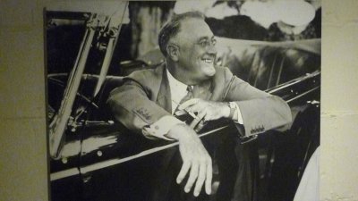 FDR looking happy behind the wheel of the car. Note the cigarette that was probably ejected automatically by the car!
