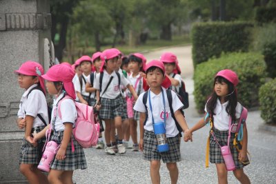 They wore school uniforms, with green or pink hats.