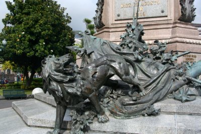 Below the statue is a sculpture of a lion wounded by an arrow.  A condor with unfolded wings carries broken chains in its claws.