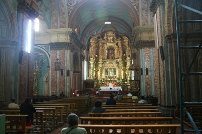 Interior of the Church of El Sagrario in Quito with its golden carved alter in the background.