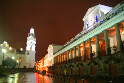 A rainy night photo of Plaza Grande with the Presidential Palace and the Metropolitan Cathedral steeple in the background.