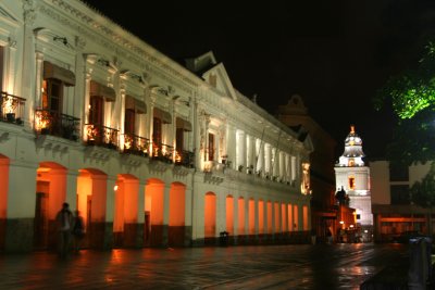 Side view of the arched colonnade of the Archbishop's Palace at night.