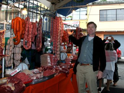 Me pointing proudly to a sausage and meat stand in the market.