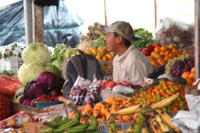 A fruit and vegetable vendor amongst his produce.