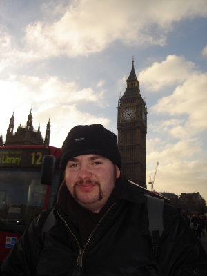Matthew with Big ben and a red london bus.JPG