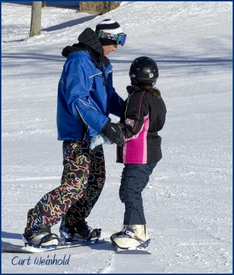 Snow board instructor assisting student