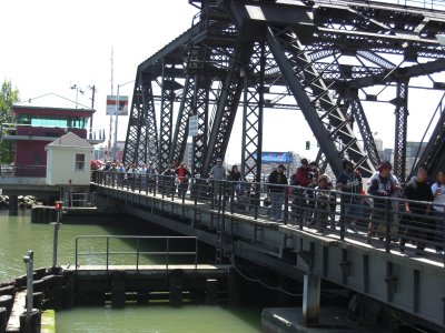 Baseball fans walk over Lefty O'doul Bridge from their cars to the baseball park