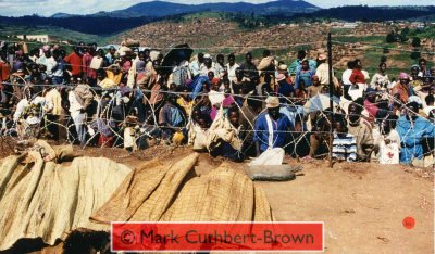 Views from within the Zambian Company of the United Nations Assistance Mission for Rwanda (UNAMIR) at about 14:30 on Tuesday, 18 April 1995. Note the relative calm, despite great pressure around the camp, which, in some places has broken down razor-wire fencing. Note also the high proportion of adult and adolescenace males.