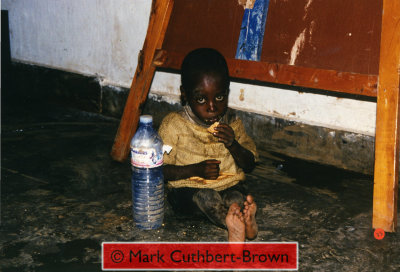 A rescued child eats biscuits in the Zambian company base late in the afternoon of Saturday 22 April.  He was one of about 350 rescued and taken to orphanages on Sunday morning, 23 April,