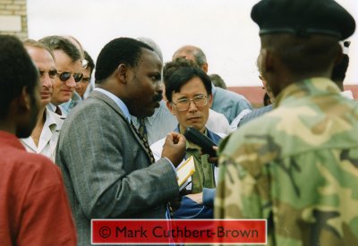 Bizimungu, surrounded by UN officials (including RR Hasegawa and Randolph Kent - Head of the UN's Rwanda Emergency Operation) and RPA soldiers, is interviewed by local radio.