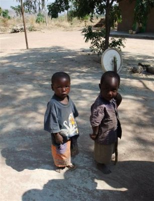 Bukumbi village - boy with plastic lid on stick