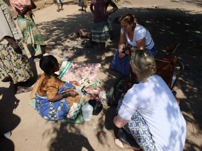 Bukumbi village - lady who has lost many of her fingers through leprosy, now making mats,