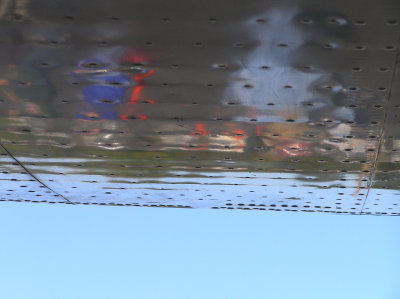 People reflected in the underside of a wing